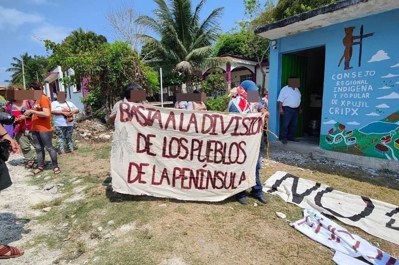 Personen mit einem Banner stehen vor dem Haus des CRIPX
