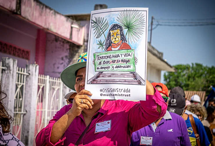 Frau mit Plakat gegen den Tren Maya