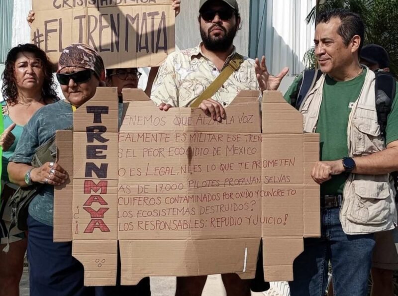 Aktivist*innen mit einem Plakat gegen den Tren Maya