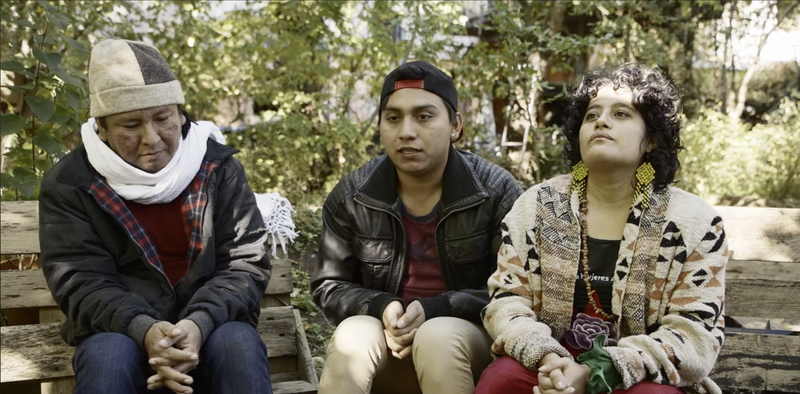 Juan Camaal Pech und zwei Weitere Personen sitzen auf einer Bank