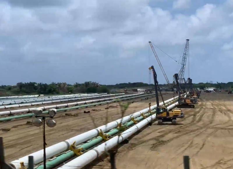 Baumaschinen arbeiten bei verschiedenen, parallel liegenden Pipelines